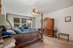 Carpeted bedroom featuring ceiling fan and baseboards