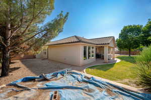 Back of property featuring a patio, stucco siding, a tiled roof, and a ceiling fan