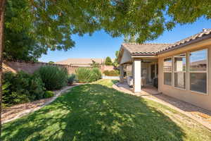 Fenced backyard featuring a patio area and ceiling fan