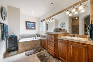 Bathroom featuring double vanity, a garden tub, a walk in shower, light tile patterned floors, and recessed lighting