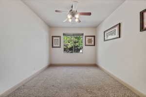 Empty room featuring carpet floors and ceiling fan