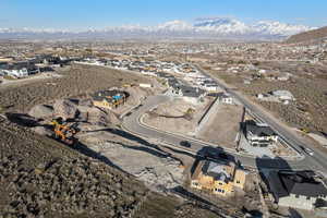 Aerial view of property and surrounding area featuring a mountain backdrop and nearby suburban area