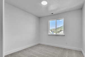 Unfurnished room featuring light carpet and baseboards