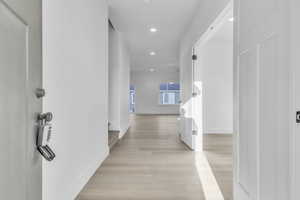 Hall with recessed lighting and light wood-style flooring