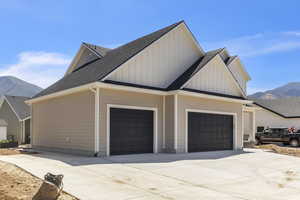 View of side of property featuring a mountain view, board and batten siding, and a shingled roof