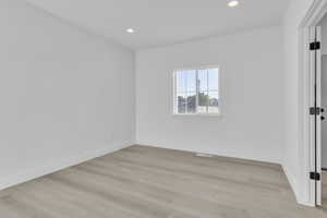 Empty room featuring recessed lighting and light wood-style floors