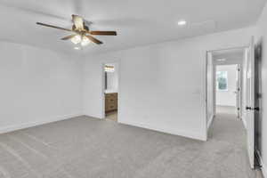Unfurnished bedroom featuring light colored carpet, recessed lighting, connected bathroom, and ceiling fan