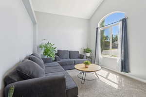 Living room with light title flooring and vaulted ceiling