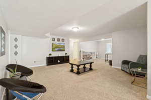 Living room featuring light colored carpet and a textured ceiling