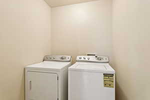 Washroom with washer and clothes dryer and a textured ceiling