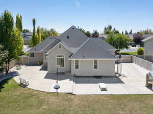Back of property with a fenced backyard, a patio area, stucco siding, and roof with shingles