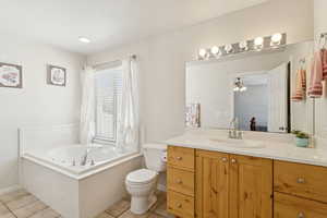 Ensuite bathroom with vanity, a garden tub, and light tile patterned flooring and  shower