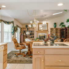 Kitchen with recessed lighting, light brown cabinets, vaulted ceiling, a fireplace, and white dishwasher
