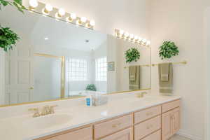 Bathroom featuring double vanity, a shower stall, and a bath