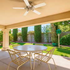Fenced backyard featuring outdoor dining space, ceiling fan, and a patio area