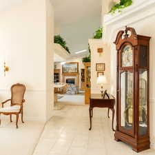 Corridor featuring light tile patterned flooring and a towering ceiling