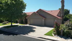 View of front of house featuring a garage, stucco siding, driveway, and a tile roof