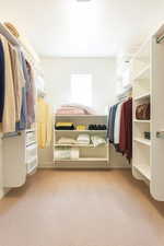 Spacious closet with light carpet