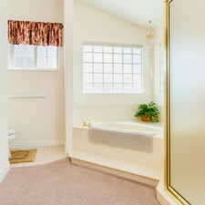 Full bathroom featuring a stall shower, a garden tub, plenty of natural light, and light tile patterned flooring