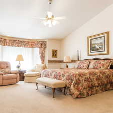 Carpeted bedroom featuring a ceiling fan