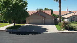View of front of property with an attached garage, stucco siding, a tiled roof, and concrete driveway