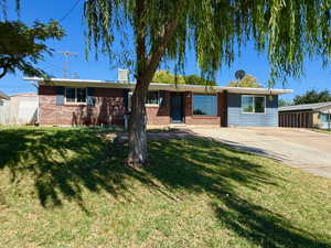 Single story home featuring brick siding and a front yard