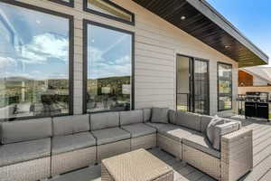 Wooden terrace with an outdoor hangout area and area for grilling