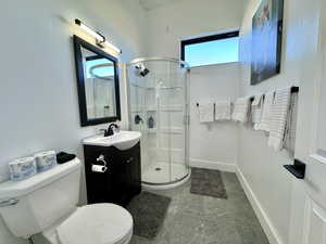 Full bathroom featuring vanity, a stall shower, and tile patterned flooring