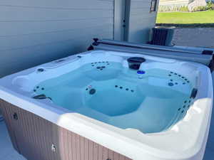 Full bath featuring a tub with jets and wood walls