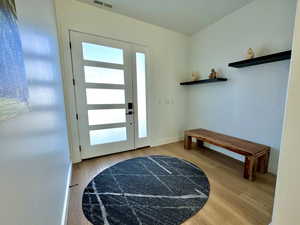 Doorway with wood finished floors and baseboards