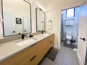 Bathroom featuring dark tile patterned flooring and double vanity