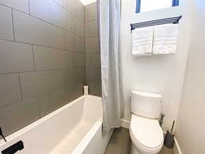 Bathroom featuring toilet and shower / bath combo
