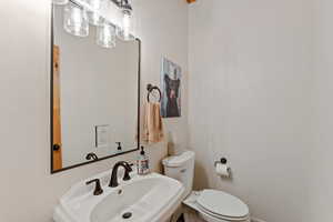 Half bathroom with toilet and a sink