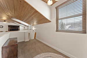Additional living space featuring wood ceiling, carpet floors, and ceiling fan