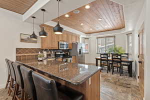Kitchen featuring wood ceiling, recessed lighting, backsplash, decorative light fixtures, and stainless steel appliances