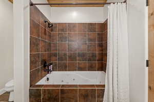 Full bath featuring a combined bath / shower with jetted tub