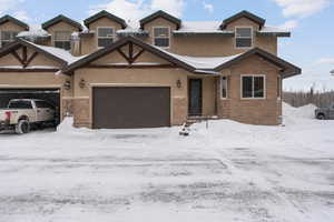 View of front facade featuring stone siding and stucco siding