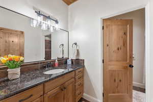 Bathroom featuring vanity and dark tile patterned floors