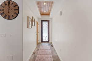 Entryway with stone finish floors, wooden ceiling, and recessed lighting