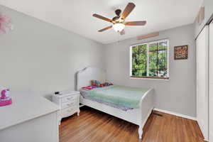 Bedroom featuring light wood finished floors, a closet, and ceiling fan
