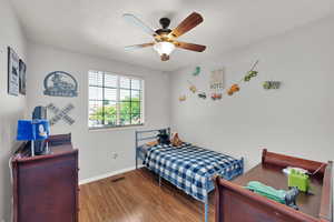 Bedroom featuring wood finished floors and a ceiling fan
