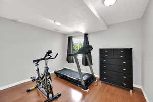 Workout room with light wood-style floors and baseboards