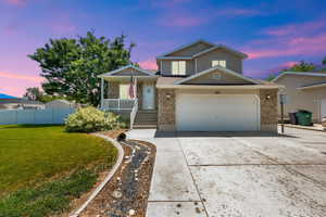 View of front facade with concrete driveway, brick siding, a porch, and an attached garage
