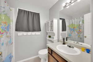 Full bathroom featuring vanity, a textured ceiling, and a shower with shower curtain