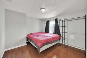 Bedroom featuring wood finished floors and baseboards