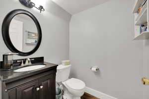 Half bath with a textured ceiling and vanity