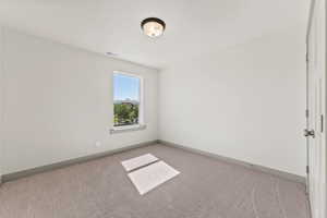 Unfurnished room featuring light colored carpet and baseboards