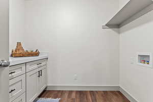 Laundry area featuring dark wood-style floors and baseboards