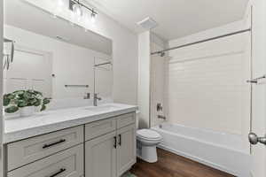 Full bathroom featuring bathing tub / shower combination, dark wood-style floors, and vanity