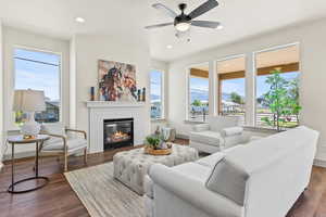 Living room featuring a fireplace, healthy amount of natural light, recessed lighting, dark wood-style flooring, and a ceiling fan
